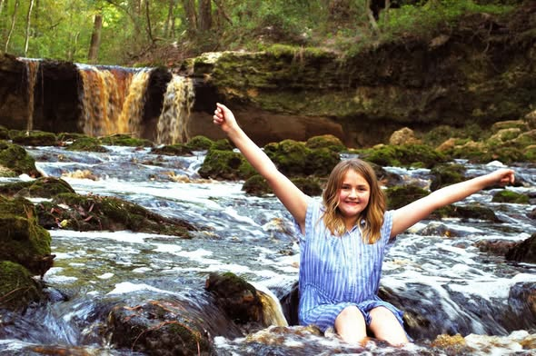 happy girl near waterfall